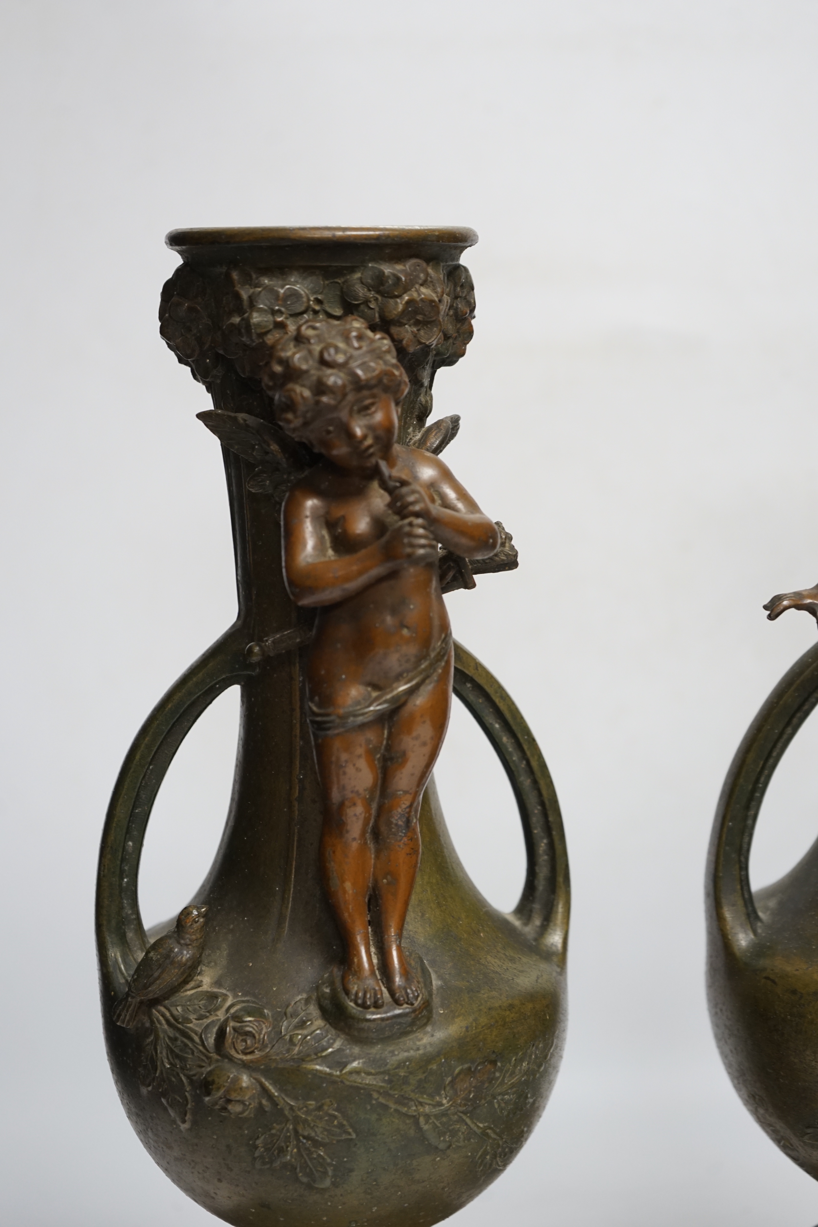 After Hippolyte François-Moreau (1832-1927), a pair of bronzed spelter cherubic vases on marble bases, 42cm